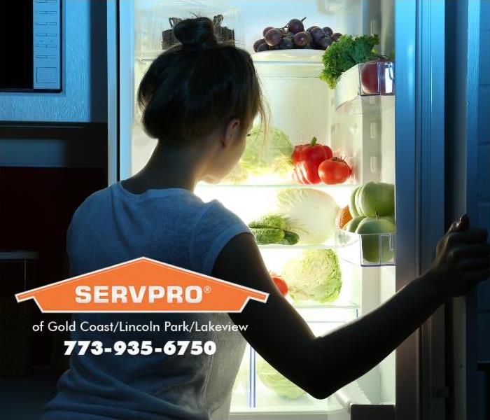 A person is looking at the food inside a refrigerator.