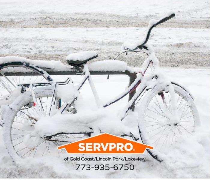 A bicycle is shown frozen in snow. 